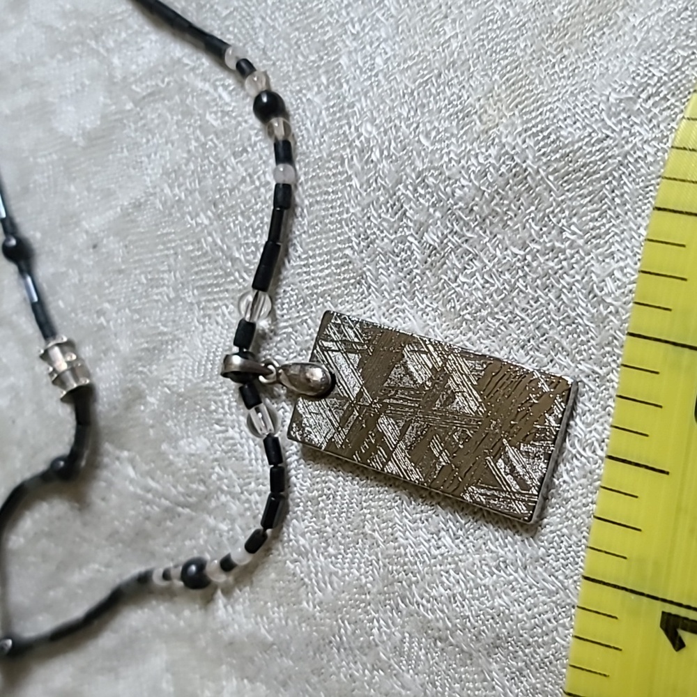 Genuine natural Muonionalusta iron meteorite pendant on necklace.
